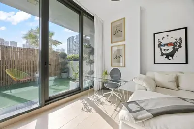 a living room with a couch and a glass table at Trendy Marina 2-Bedroom Apartment in Dubai