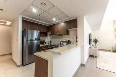 a kitchen with a stainless steel refrigerator and cabinets at Cozy 2BR Near Zabeel Park - Dubai frame view in Dubai