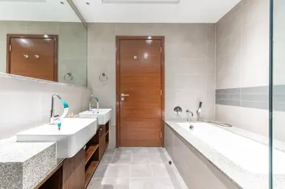 a bathroom with two sinks and two mirrors at Cozy 2BR Near Zabeel Park - Dubai frame view in Dubai