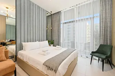 a bedroom with a bed and a chair and a window at New Stylish Apartment, Metro 5min walk, Dubai Marina 20min in Dubai