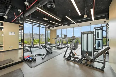 a gym with treadmills and cardio equipment and windows at New Stylish Apartment, Metro 5min walk, Dubai Marina 20min in Dubai
