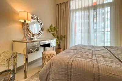 a bedroom with a bed and a mirror and a window at Coozy one bedroom in Al Jaddaf Dubai in Dubai