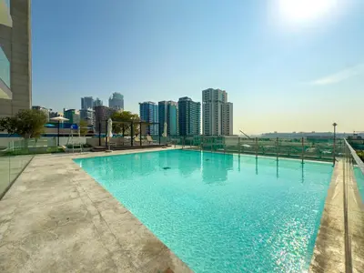 a swimming pool with a city skyline in the background at Private Jacuzzi Canal view - Near Burj Khalifa in Dubai