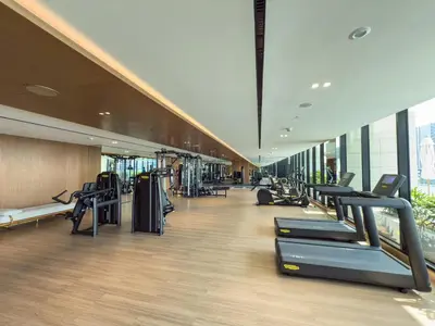 a gym with treadmills and machines in a building at Private Jacuzzi Canal view - Near Burj Khalifa in Dubai