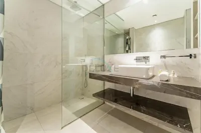 a bathroom with a sink and a glass shower at Community View 1BR, Just 15minutes to Miracle Garden - Oxford Boulevard, Jumeirah Village Circle by Deluxe Holiday Homes in Dubai