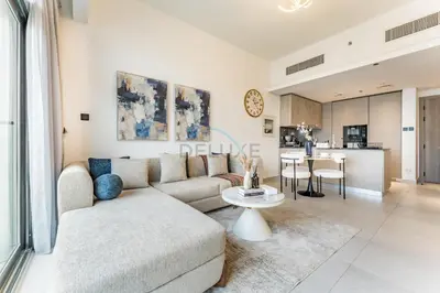 a living room with a couch and a table at Community View 1BR, Just 15minutes to Miracle Garden - Oxford Boulevard, Jumeirah Village Circle by Deluxe Holiday Homes in Dubai
