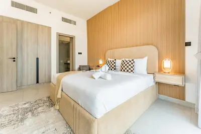 a bedroom with a large bed in a room at Community View 1BR, Just 15minutes to Miracle Garden - Oxford Boulevard, Jumeirah Village Circle by Deluxe Holiday Homes in Dubai