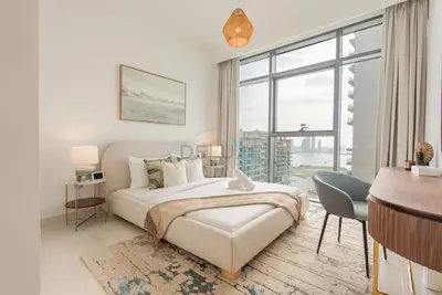a bedroom with a bed and a desk and a window at Stunning View, Easy Access to Dubai Attraction, Beach Vista Tower 2, Emaar Beachfront by Deluxe Holiday Homes in Dubai