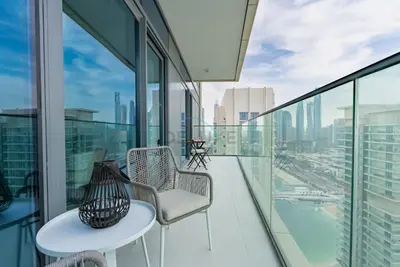 a balcony with two chairs and a table on a building at Stunning View, Easy Access to Dubai Attraction, Beach Vista Tower 2, Emaar Beachfront by Deluxe Holiday Homes in Dubai