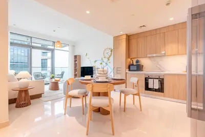 a kitchen and living room with a table and chairs at Stunning View, Easy Access to Dubai Attraction, Beach Vista Tower 2, Emaar Beachfront by Deluxe Holiday Homes in Dubai