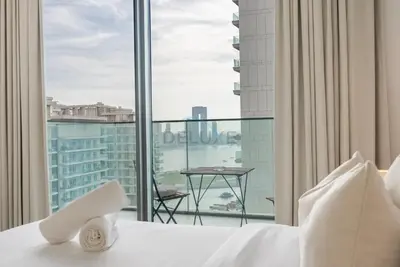a hotel room with a bed and a large window at Stunning View, Easy Access to Dubai Attraction, Beach Vista Tower 2, Emaar Beachfront by Deluxe Holiday Homes in Dubai