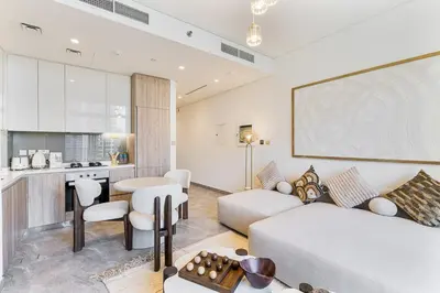 a living room with a white couch and a kitchen at Luxury 1Bed with Canal Views Near Burj Khalifa in Dubai