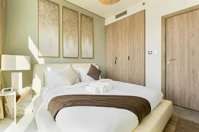 a bedroom with a large white bed with two towels at Luxury 1Bed with Canal Views Near Burj Khalifa in Dubai