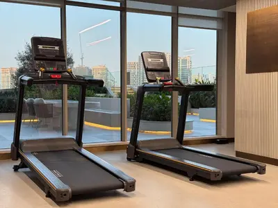 two elliptical exercise machines in a room with windows at Pearl House 2 in Dubai