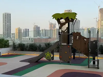 a slide in a playground with a city in the background at Pearl House 2 in Dubai