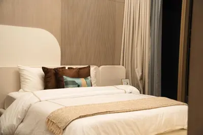 a bedroom with a large bed with white sheets and pillows at Pearl House 2 in Dubai
