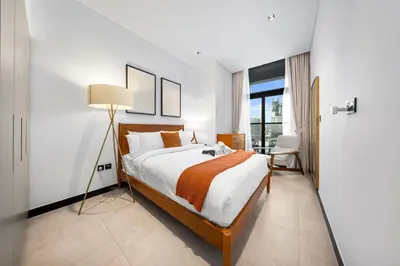 a bedroom with a large bed and a lamp at StayShort - 1 Bedroom Sleeps 2 with City Views in Business Bay in Dubai