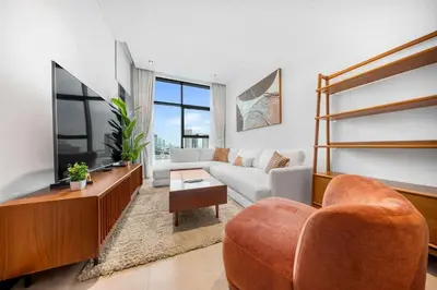 a living room with a couch and a tv at StayShort - 1 Bedroom Sleeps 2 with City Views in Business Bay in Dubai