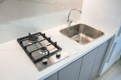a kitchen counter with a stove and a sink at Burj Khalifa View Studio 10 mins away Dubai Mall in Dubai