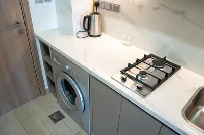 a kitchen with a stove and a washing machine at Burj Khalifa View Studio 10 mins away Dubai Mall in Dubai