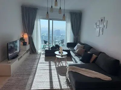 a living room with a couch and a tv at Spacious 1Bed with Golf Course and Marina View in Dubai