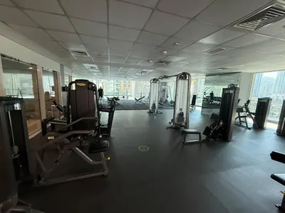 a gym with cardio equipment in a large room at Spacious 1Bed with Golf Course and Marina View in Dubai