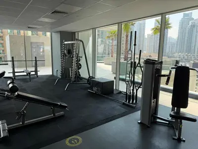 a gym with cardio equipment and a view of the city at Spacious 1Bed with Golf Course and Marina View in Dubai