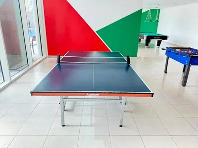 a ping pong table in the middle of a room at Spacious 1Bed with Golf Course and Marina View in Dubai