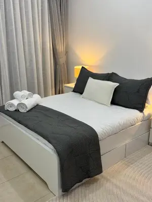 a bedroom with a bed with two towels on it at Spacious 1Bed with Golf Course and Marina View in Dubai
