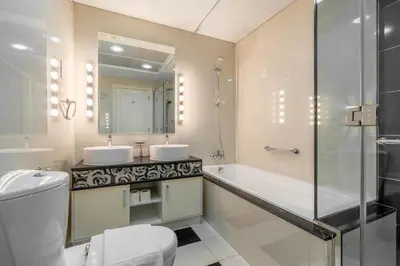 a bathroom with two sinks and a tub and a toilet at High floor downtown apartment opposite Dubai Mall in Dubai