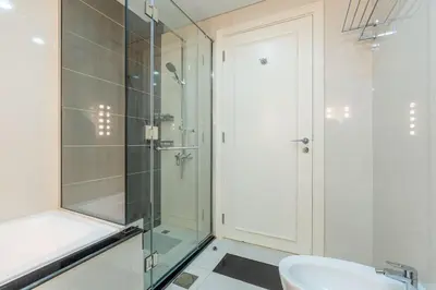 a bathroom with a glass shower and a sink at High floor downtown apartment opposite Dubai Mall in Dubai
