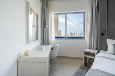 a bedroom with a desk and a bed and a window at High floor downtown apartment opposite Dubai Mall in Dubai