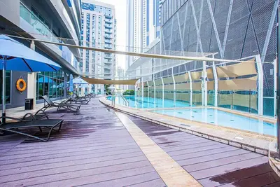 a swimming pool in a building with tables and chairs at High floor downtown apartment opposite Dubai Mall in Dubai