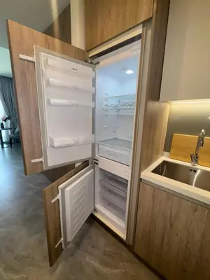 an empty refrigerator with its door open next to a sink at Cozy studio with Burj Khalifa and canal view in Dubai