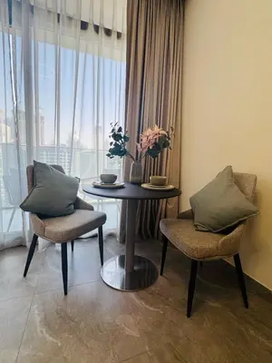a dining room with a table and chairs and a window at Cozy studio with Burj Khalifa and canal view in Dubai