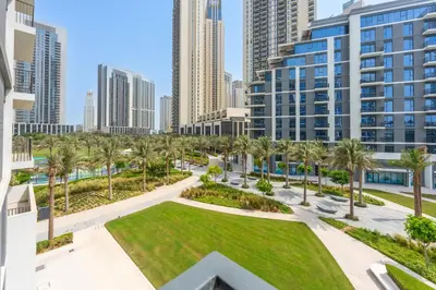a view of a park with palm trees and buildings at ShoresInn - Luxury Dubai Creek Harbour Stay in Dubai