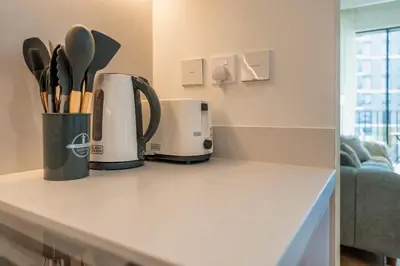 a kitchen counter with a coffee maker and utensils at ShoresInn - Luxury Dubai Creek Harbour Stay in Dubai