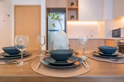 a table with plates and glasses and a vase at ShoresInn - Luxury Dubai Creek Harbour Stay in Dubai