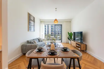 a living room with a table and a couch at ShoresInn - Luxury Dubai Creek Harbour Stay in Dubai