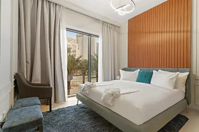 a bedroom with a bed and a large window at Elegant 1BR at Lotus Creek Beach Lagoon Living in Dubai