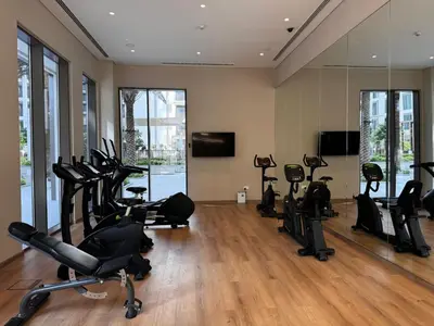 a gym with several treadmills and exercise bikes at Elegant 1BR at Lotus Creek Beach Lagoon Living in Dubai