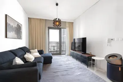 a living room with a couch and a tv at Spacious 1BR in Creek Harbour with Gym and Pool in Dubai