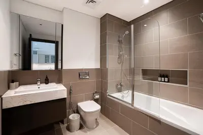a bathroom with a toilet and a sink and a shower at Spacious 1BR in Creek Harbour with Gym and Pool in Dubai