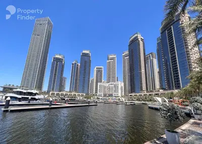 a city with tall buildings and a river with boats at Spacious 1BR in Creek Harbour with Gym and Pool in Dubai