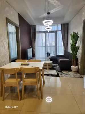 a living room with a table and chairs and a couch at Majestic Canal View 2Bhk 6pax in Dubai