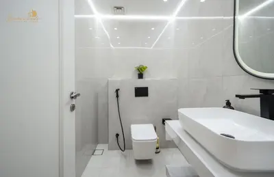 a white bathroom with a sink and a toilet at Deluxe Beach Residence 2Bhk, 8pax in Dubai
