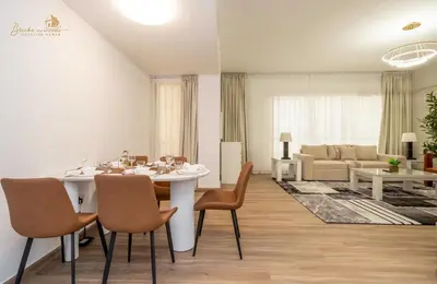 a kitchen and living room with a table and chairs at Deluxe Beach Residence 2Bhk, 8pax in Dubai