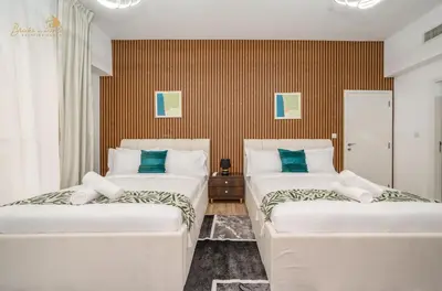 two beds in a room with blue pillows at Deluxe Beach Residence 2Bhk, 8pax in Dubai