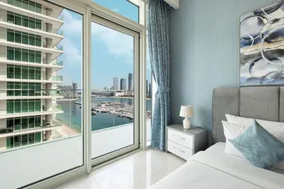 a bedroom with a large window with a view of a harbor at 2 Bedroom Apartment in Emaar Beachfront with Palm and Marina Views in Dubai