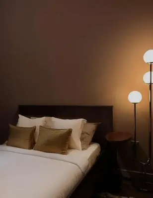 a bedroom with a bed with white sheets and pillows at Modern Japanese and Arabic Fusion City Stay that is 10 min from Dubai Mall in Dubai
